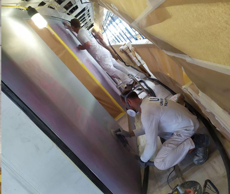 man-applying filler on superyacht surface